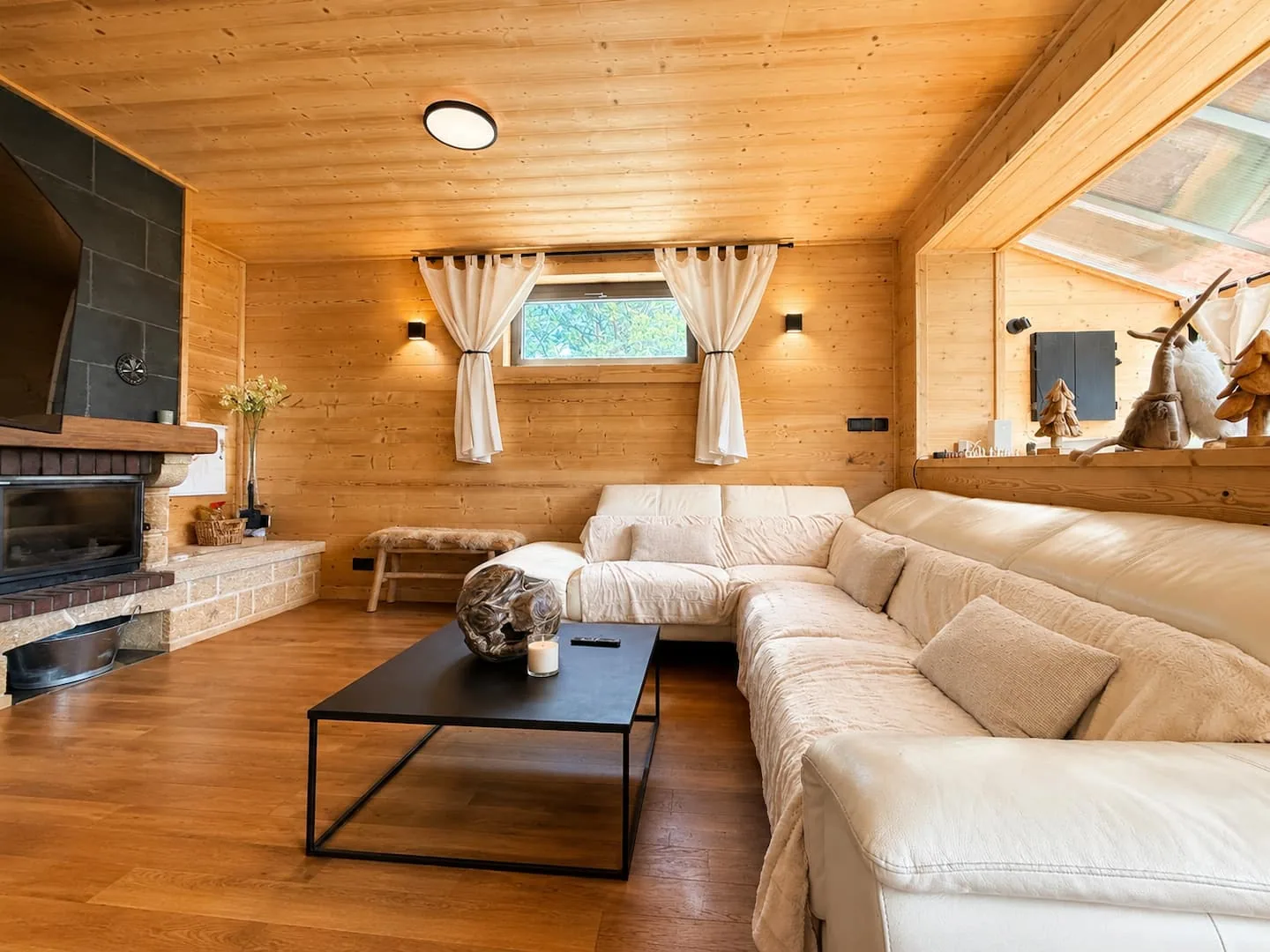 Grand salon lumineux du Chalet Isard avec cheminée et murs en bois