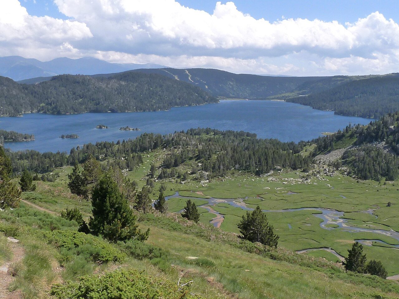 Lac des Bouillouses and the River Têt surrounded by mountains in summer